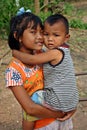 The girl holds younger brother.